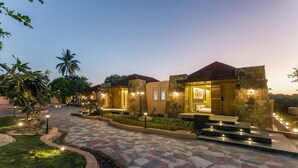 A modern hotel with stone facades, a stone pathway, and outdoor lighting. - Wild forest Sasan Gir Wildlife Sanctuary (Mendarda)