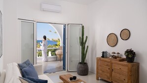 Ein modernes Wohnzimmer mit einer Couch, einem Holzkabinett und einer großen Sukkulente.
