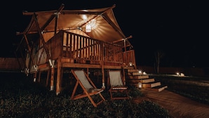 Een houten chalet met een balkon en twee loungestoelen.