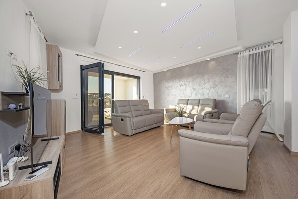 A modern living room with a sofa, a coffee table, and a TV stand. - Villa golfista - An Architectural Jewel Steps from the Sea (pjescana uvala)