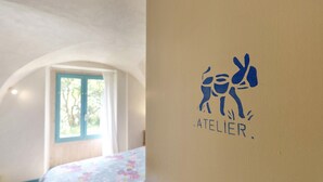 Una stanza con un letto, una finestra e una parete con un logo.