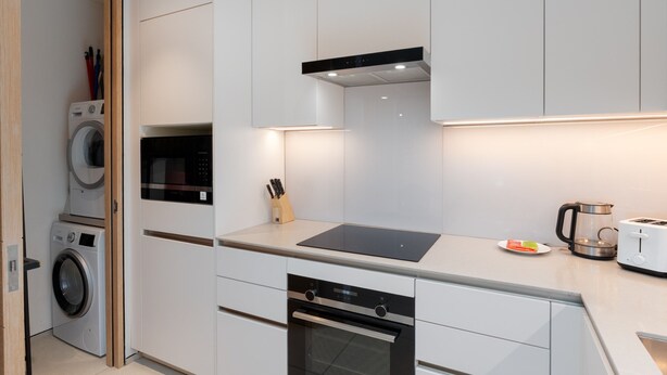 A modern kitchen with built-in appliances, a dishwasher, and a coffee maker. - Address JBR 2BR Steps to Beach Bluewaters (Dubai)