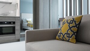 A modern living room with a sofa and a patterned throw pillow. - Dobo Madrid Las Torres (Madrid)