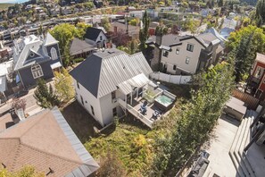 Ein Wohngebiet mit Häusern, einem Whirlpool auf einer Terrasse und einem wolkenlosen Himmel.