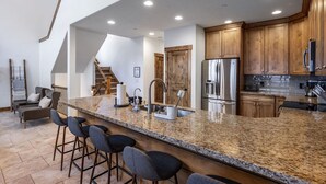 A modern kitchen with granite countertops, stainless steel appliances, and wooden cabinets. - Summer by the Lake! Beautiful Swimming Pool, Patio Hot Tub Firetable BBQ Nature Trails Hiking Biking (Kamas)