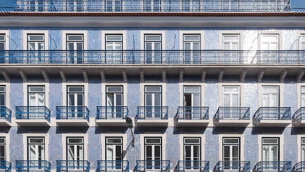 Un edificio con numerosi balconi e finestre, caratterizzato da piastrelle a motivi blu e bianchi.