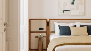 Ein Hotelzimmer mit Bett, Nachttischen und einem an der Wand hängenden Kunstwerk.