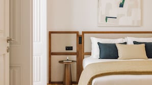 Una habitación de hotel con cama, mesitas de noche y una obra de arte colgada en la pared.