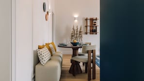 A modern living room with a sofa, a dining table with chairs, and a small side table with decorative items. - Ando Living - Abrantes 50 House - 503 (Lisbon)