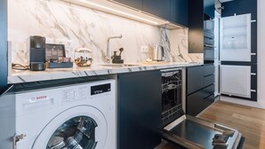 Eine moderne Küche mit einer Bosch Waschmaschine, einem Geschirrspüler und einem Kühlschrank.