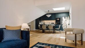 Ein modernes Loft-Apartment mit Essbereich, einer Couch und einem Sessel.