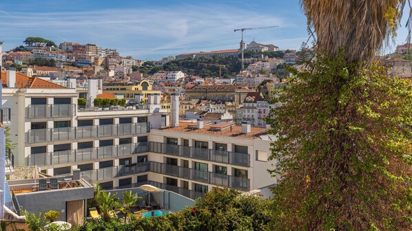 Un bâtiment moderne doté de nombreux balcons, d’une piscine et offrant une vue sur le paysage urbain.