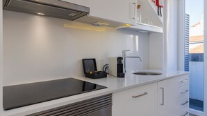 Una cocina moderna con estufa integrada, cafetera y pileta.