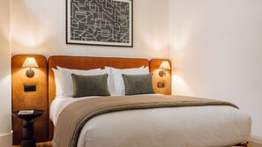 A neatly made bed with white and green pillows, a brown blanket, and two bedside tables with lamps. - Ando Living - Corpo Santo House - 201 (Lisbon)