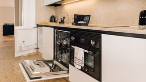 Une cuisine moderne équipée d’un lave-vaisselle, d’un four et d’une machine à café intégrés.