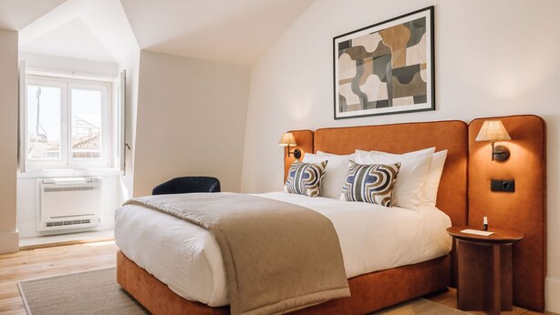 Une chambre à coucher moderne avec un grand lit, un bureau et une chaise.