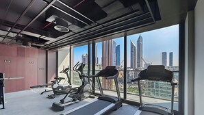 Une salle de sport moderne équipée de tapis de course, de vélos d’appartement et d’appareils elliptiques.