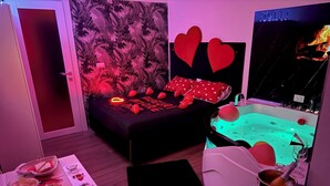 A room with a bed, a jacuzzi, and a dining area with food and drinks. - Two Hearts suite entire apartment with two rooms and Jacuzzi (Ceglie del Campo)