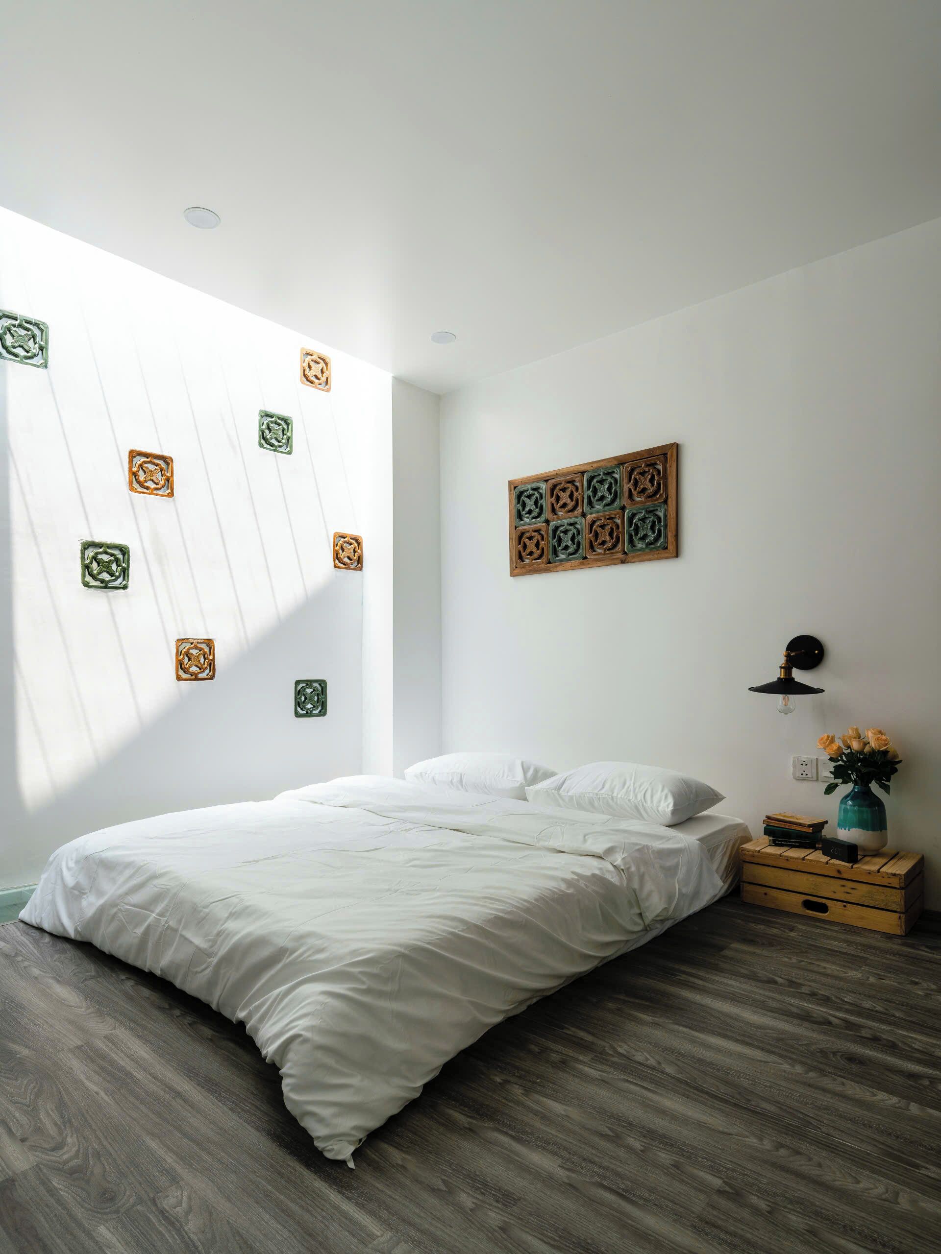 Camera da letto con un letto, un comodino in legno e decorazioni a parete.