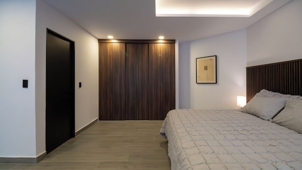 A bedroom with a bed, a wardrobe, and a framed picture on the wall. - Luxurious Room in Heart of Ciudad de México - Room M2 (Mexico City)