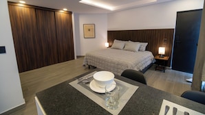 A hotel room with a bed, bedside table, and a dining area with a table set for two. - Luxurious Room in Heart of Ciudad de México - Room M2 (Mexico City)