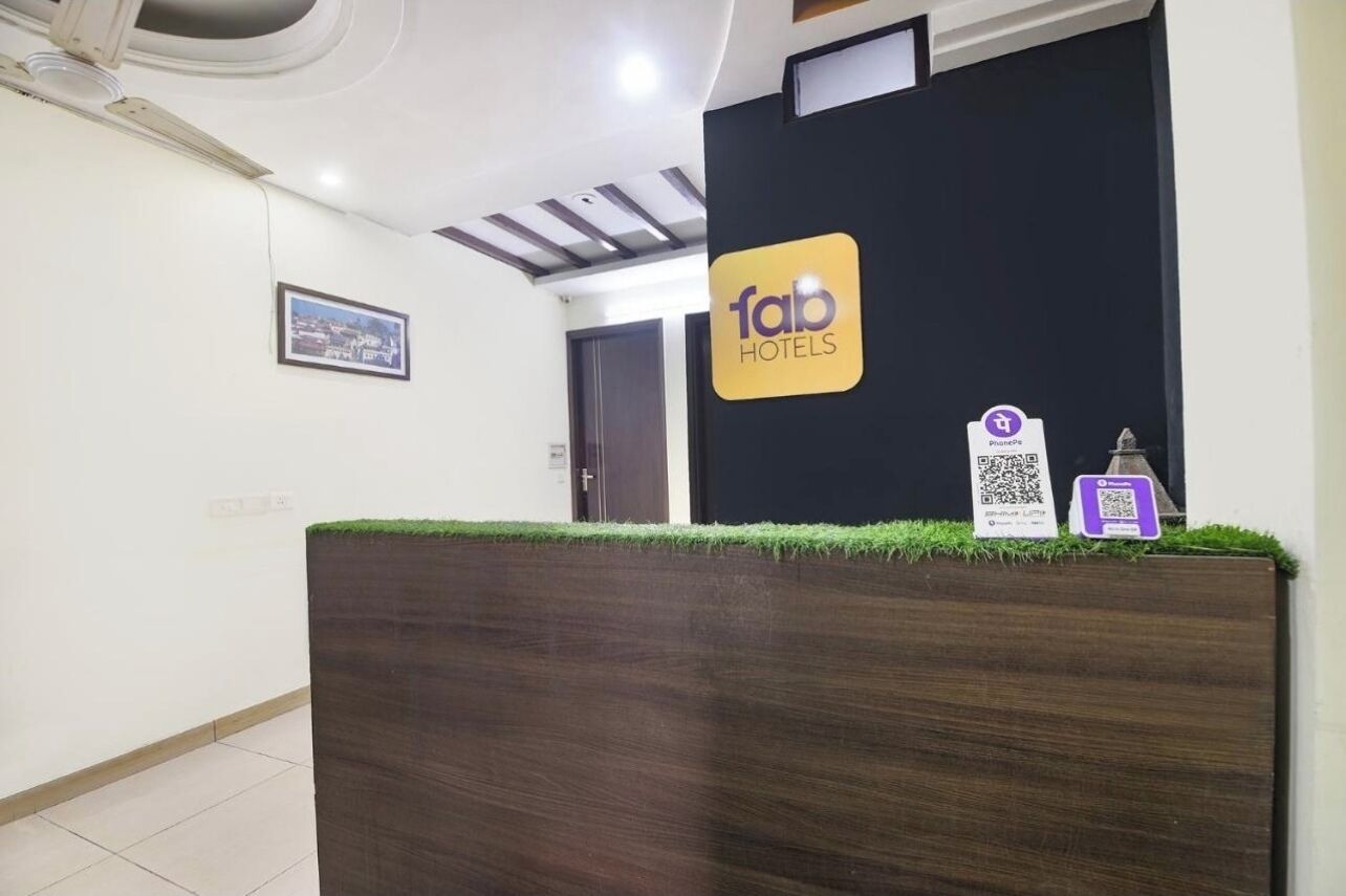 A reception desk with a 'fab hotels' sign, a QR code, and a phone icon.
