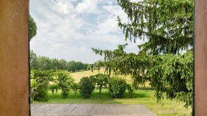 Une terrasse en bois offrant une vue sur un paysage verdoyant et des arbres.
