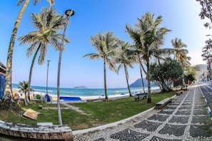 Una passeggiata costiera fiancheggiata da palme, con una spiaggia e vista sull'oceano.