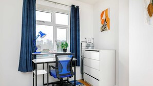A compact office space with a desk, chair, and radiator. - Charming 1-BR Apartment near Brick Lane Sleeps 3 (Greater London)