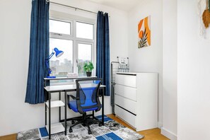 Ein kompakter Arbeitsraum mit Schreibtisch, Stuhl und Heizkörper.