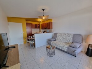 A modern living room with a sofa, a coffee table, and a TV stand.