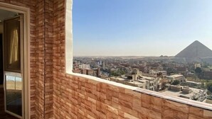 A room with a view of a cityscape and a pyramid. - Cheops Horizon Pyramids View (Giza Governorate)