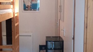 Et værelse med køjeseng, et billede af Thonon-les-Bains, en radiator og en sort varmeblæser.