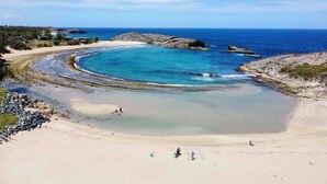 A beach with clear blue waters, a sandy shore, and rocky outcrops. - Room-mar Azul - Ocean View Private Studi (Arecibo)