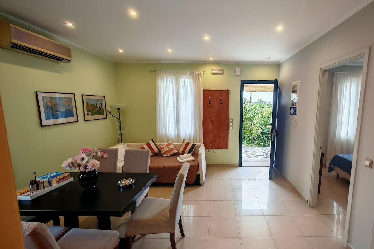 Une chambre d’hôtel comprenant un coin repas, un canapé, une armoire en bois et une vue sur l’extérieur.