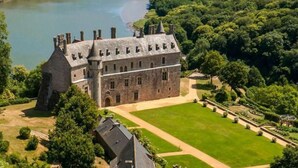 Ett stort slott med flera torn och en välskött gräsmatta framför.