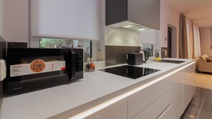 Eine moderne Küche mit Einbau-Mikrowelle, einem Kochfeld und einer großen Kochinsel.