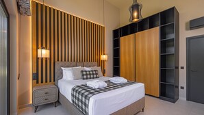 Un dormitorio moderno con una cama grande, un panel de pared de madera, armario empotrado y lámparas de noche.