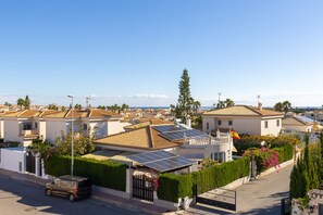 A residential area with houses, a car, and solar panels on rooftops. - Flamenca Beach by Fidalsa (Orihuela)