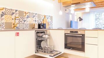 Una cocina moderna con lavavajillas, horno y un salpicadero decorado.