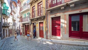Una calle adoquinada con edificios que tienen puertas rojas y balcones.
