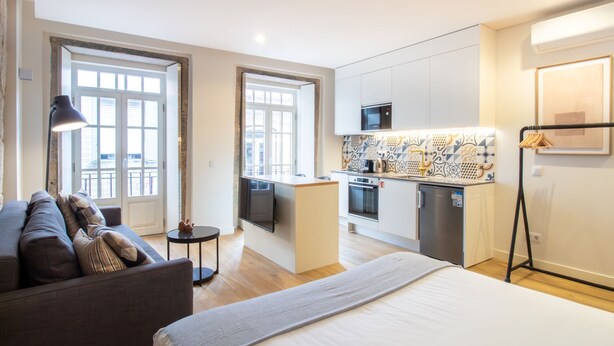 Un apartamento moderno con cocina, comedor y una cama grande.