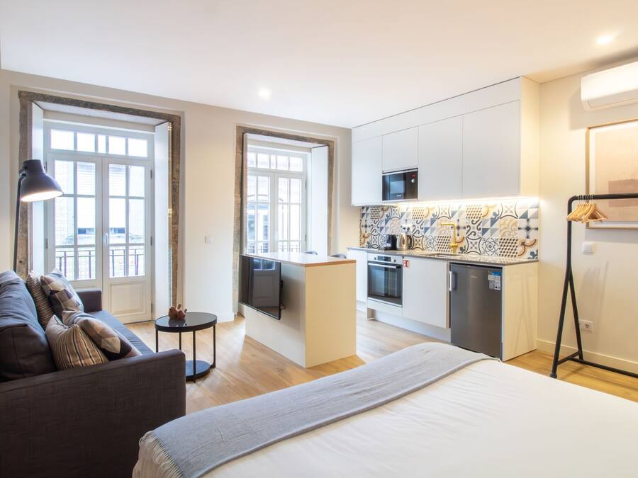 Un apartamento moderno con cocina, comedor y una cama grande.