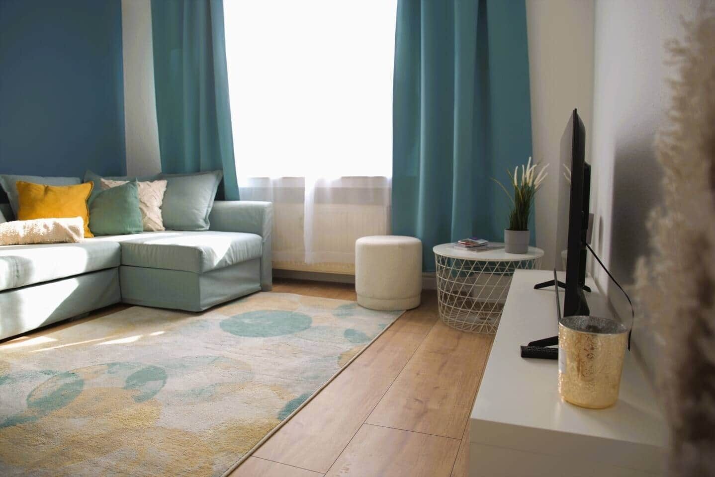 A modern living room with a sectional sofa, a coffee table, and a TV.