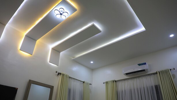 A modern bathroom with recessed lighting, a mirror, and a ceiling fan. - ED - Havilah Suites (Abuja)