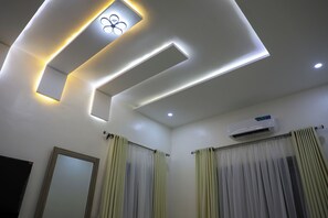 A modern bathroom with recessed lighting, a mirror, and a ceiling fan. - ED - Havilah Suites (Abuja)