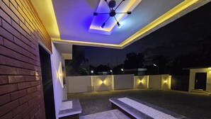 An outdoor patio area with a modern design, featuring a seating area with benches and a small table. - ED - Havilah Suites (Abuja)