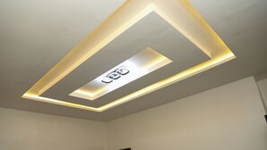 A ceiling with recessed lighting and a central light fixture. - ED - Havilah Suites (Abuja)