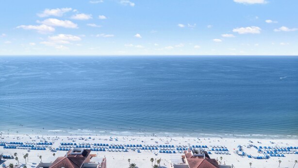 A beach with rows of blue umbrellas and white sand. - Unforgettable Luxury at Hyatt Clearwater Beach! (Clearwater Beach)