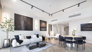 En moderne stue med sofa, sofabord og spiseplads med stole.